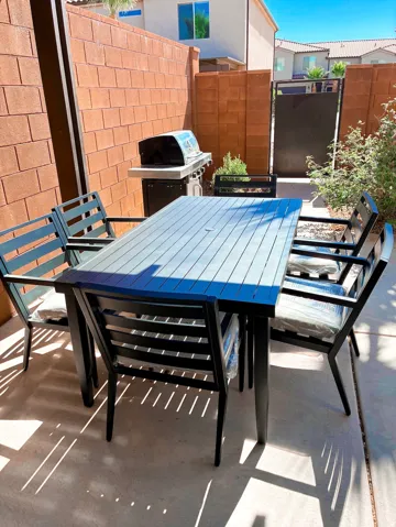 Private patio featuring a full-height block wall, concrete surface, and integrated grilling station