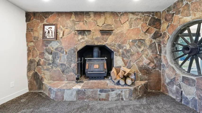 Stone-clad wall with an integrated hearth and wood-burning stove
