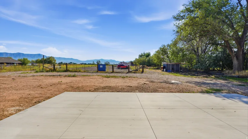 Expansive concrete patio with a natural terrain backdrop