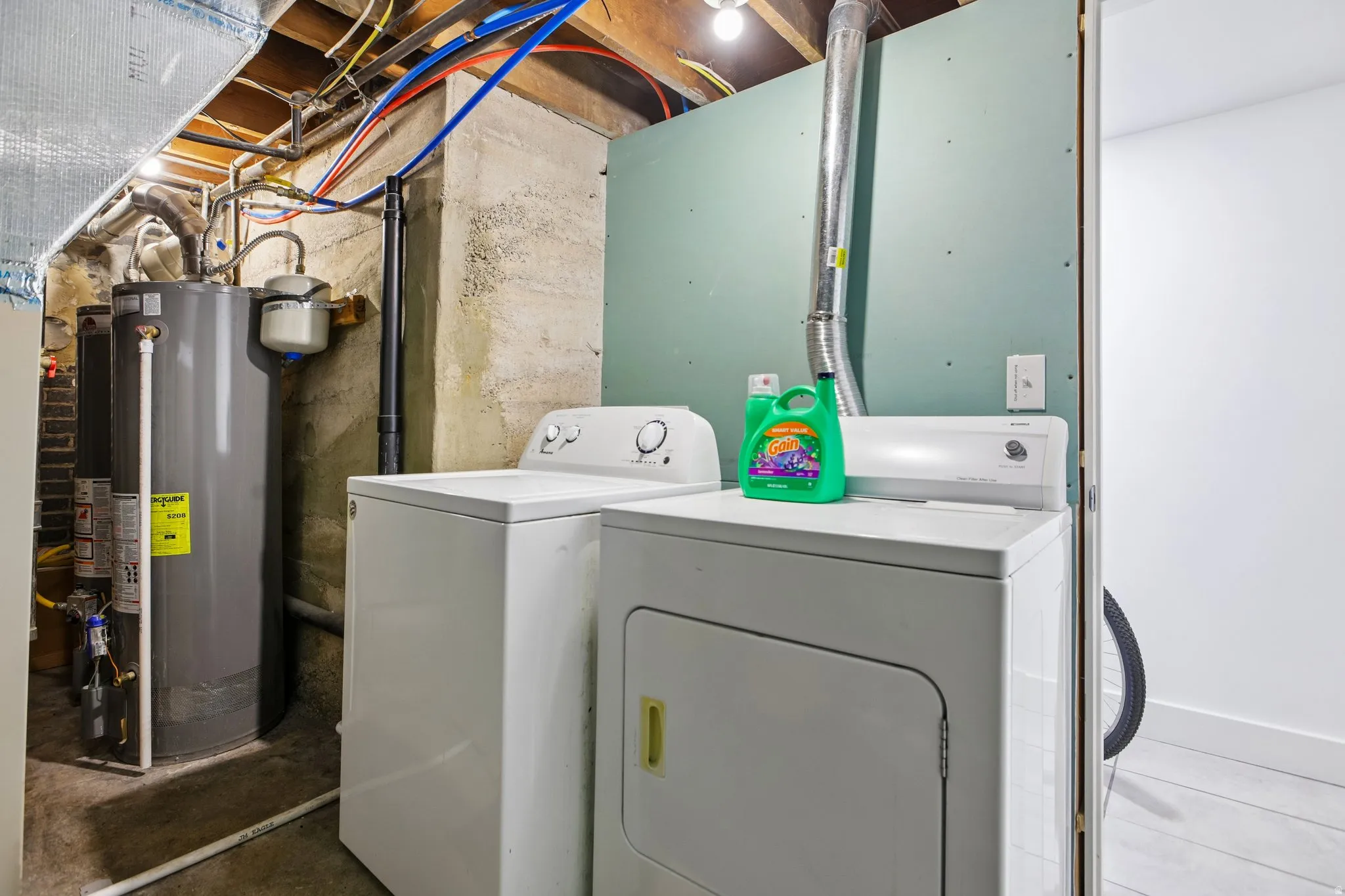 Laundry area featuring a top-load washing machine, front-load dryer, and water heater