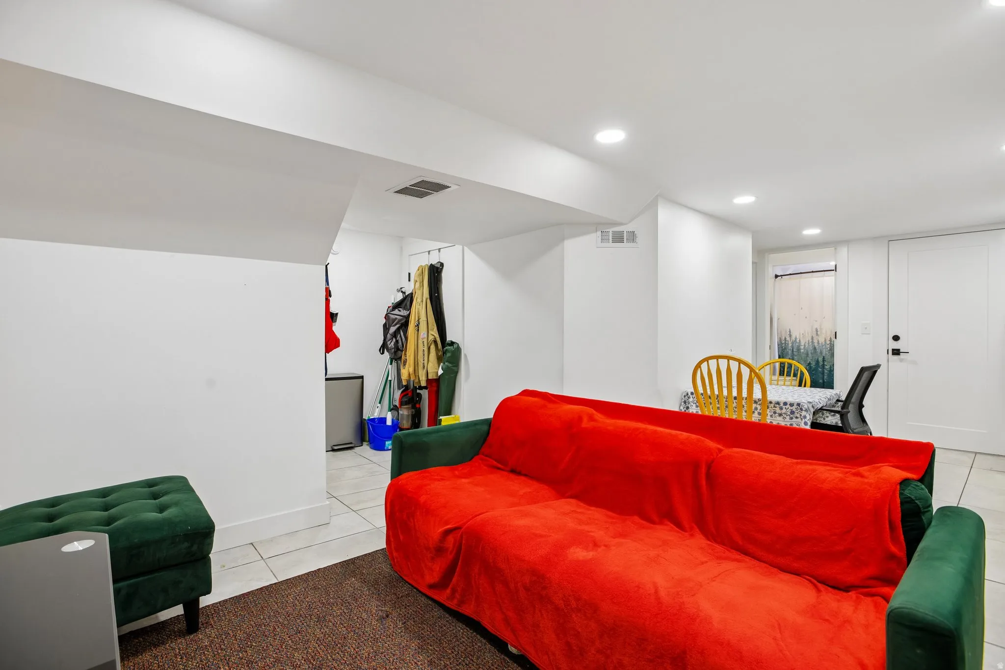 Recessed ceiling lighting, white walls, and tile flooring