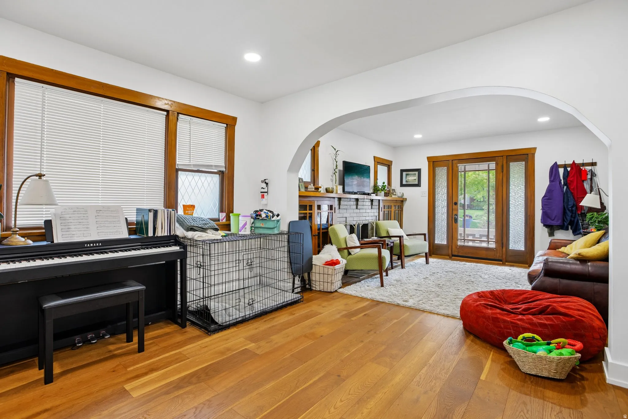 Hardwood flooring, arched doorway, recessed lighting, double glass-paneled doors, wood-trimmed windows