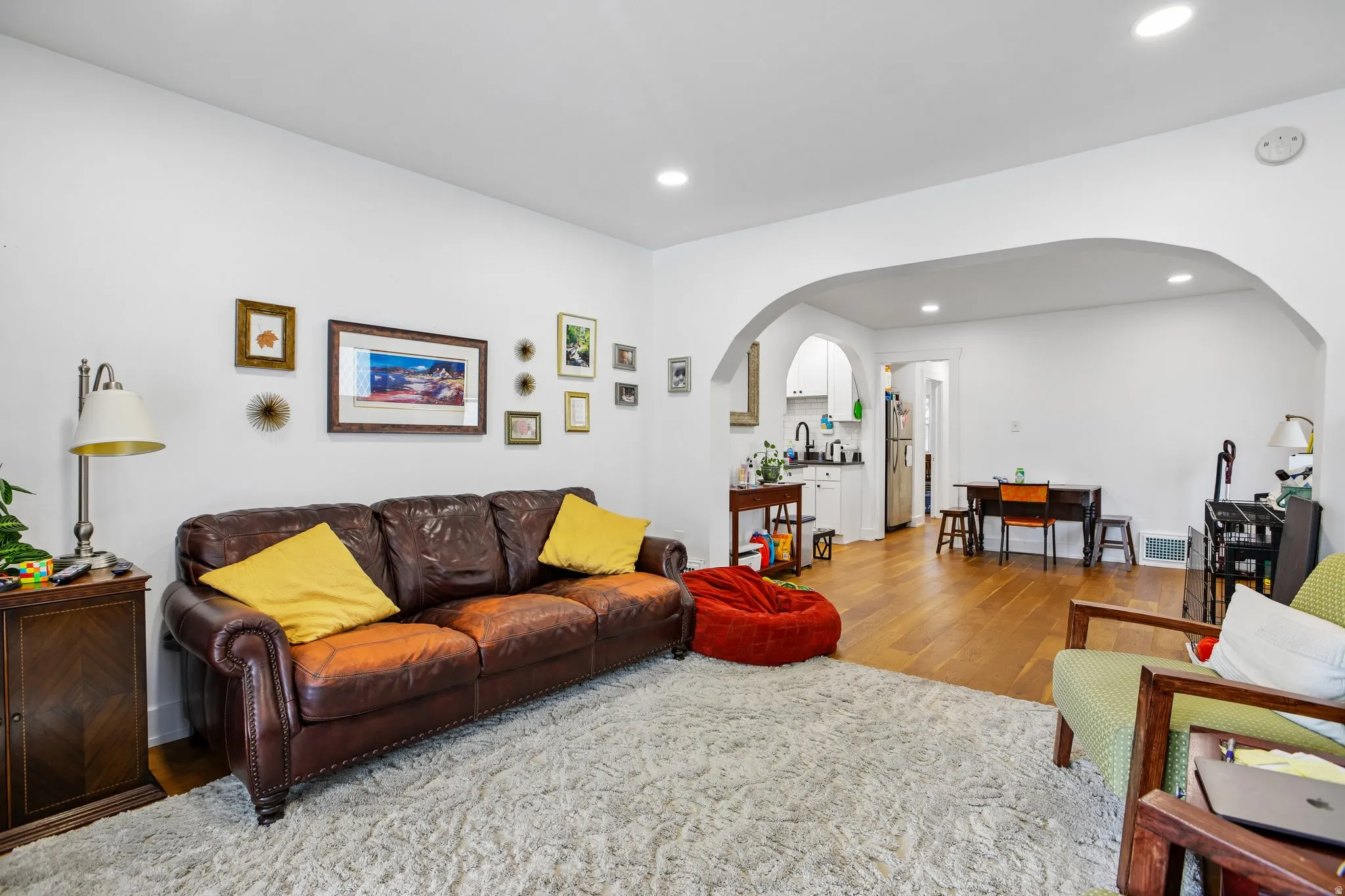 Recessed lighting illuminates the living space with wood-finish flooring