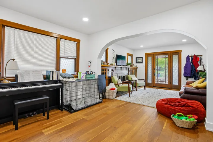 Hardwood flooring, arched doorway, recessed lighting, double glass-paneled doors, wood-trimmed windows