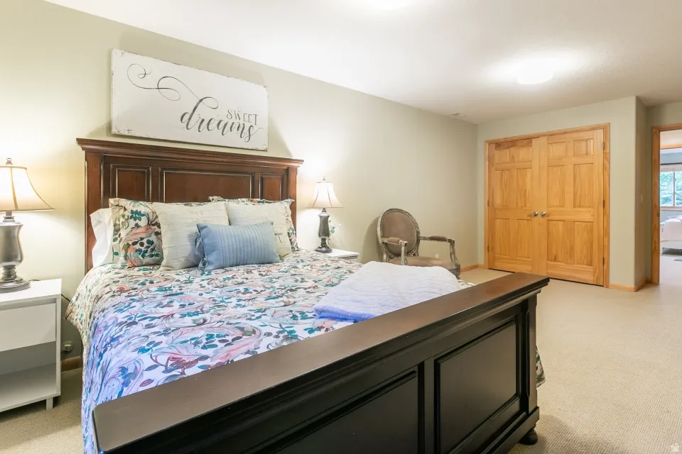 Wall-to-wall carpeting with light-toned walls and wood-finish double doors