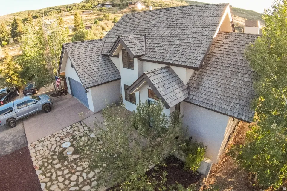 Multi-level property featuring a wood shake roof, attached two-car garage, and a concrete driveway