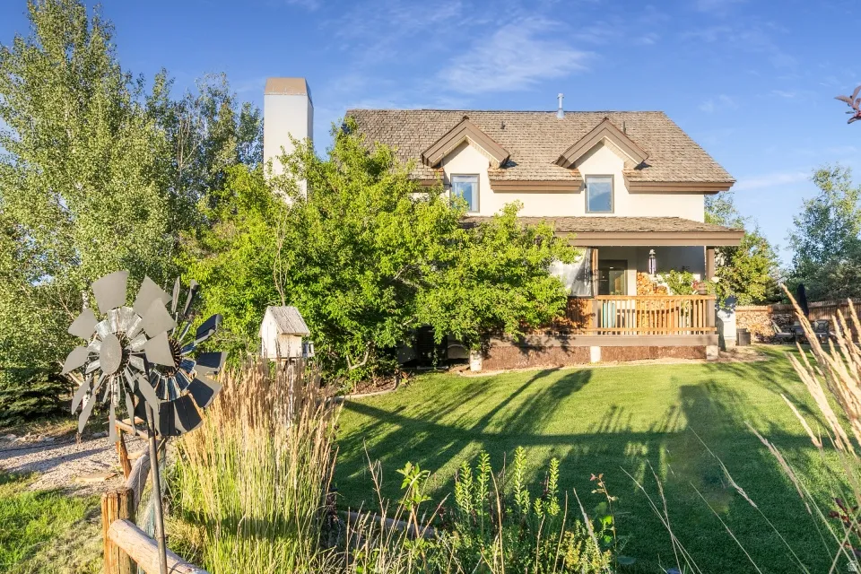 Exterior featuring a pitched roof, dormer windows, covered porch, and a well-maintained lawn