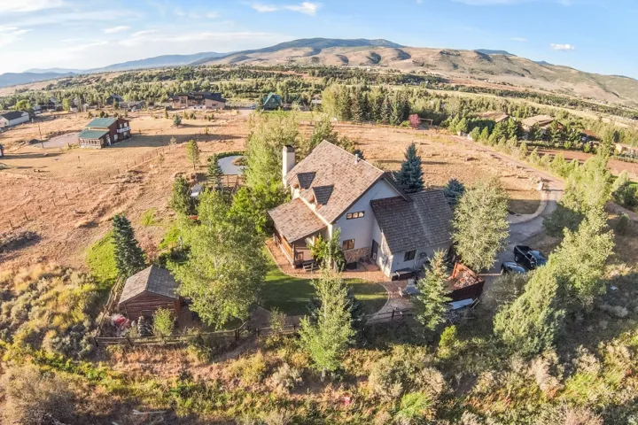 Two-story home with a multi-level roof and a stone chimney