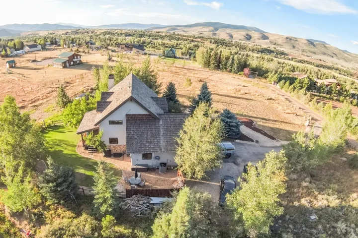 Multi-level home featuring a shake shingle roof and stone accents