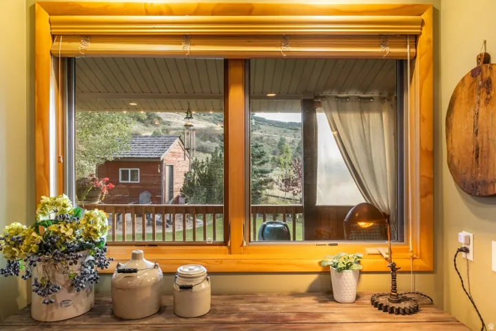 Wood-trimmed window framing a deck with a wooden railing