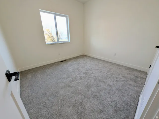 Neutral color palette, gray carpeting, white walls, and a modern window
