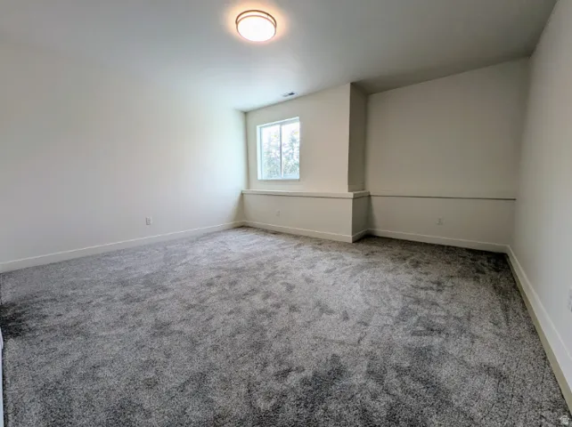 Recessed window, contemporary flush mount ceiling light, light-toned walls, and grey textured carpeting