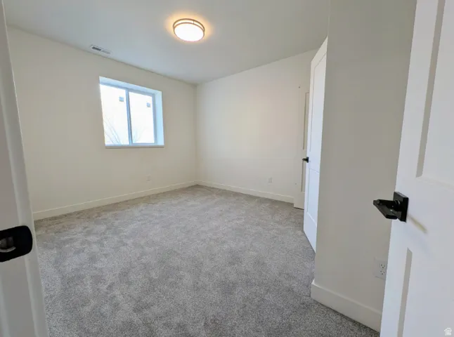 Neutral wall finishes, recessed window, flush-mount ceiling light, and gray carpet