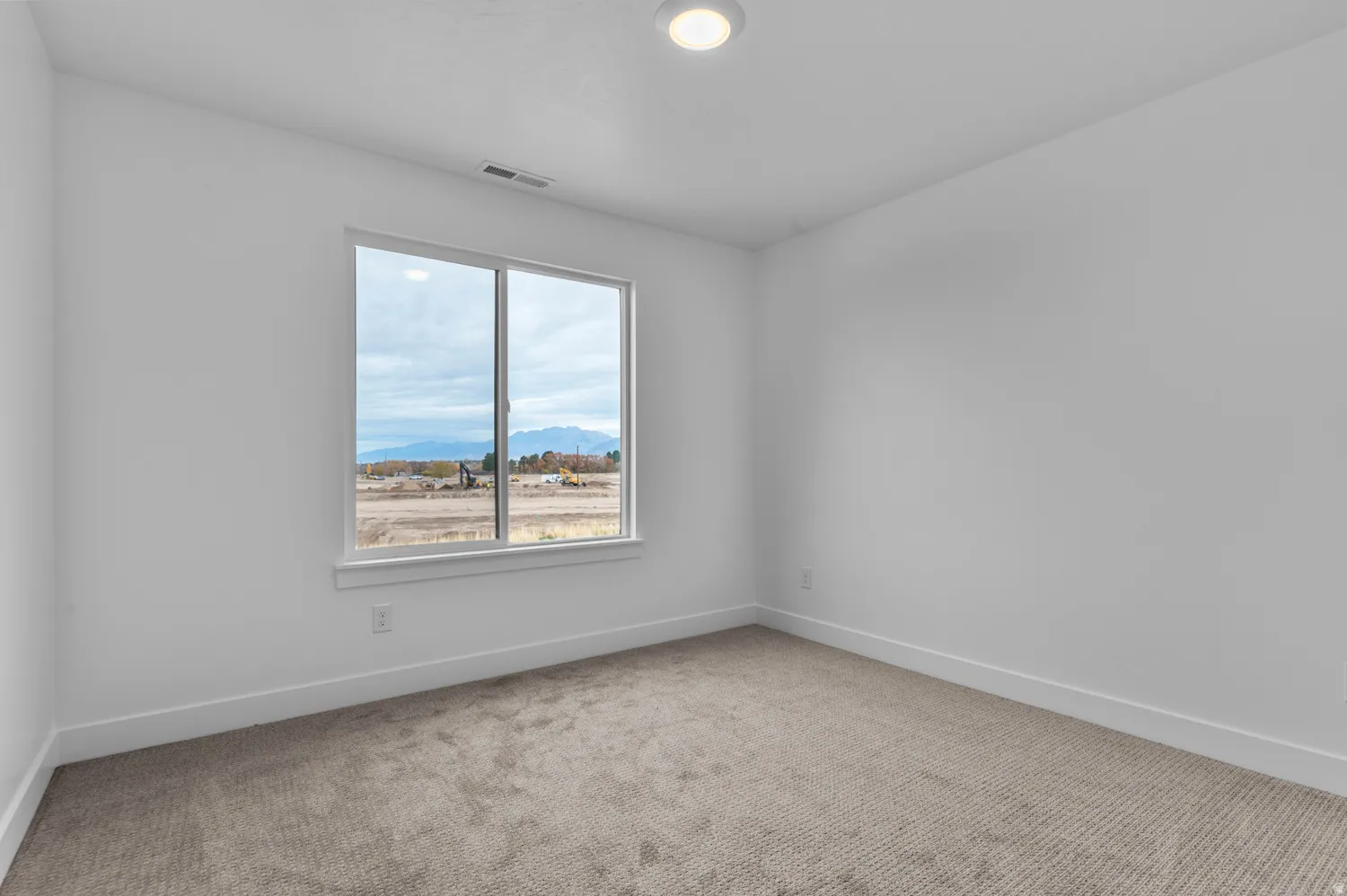 Expansive window with mountain backdrop, recessed ceiling lighting, wall-to-wall carpeting, and white baseboards
