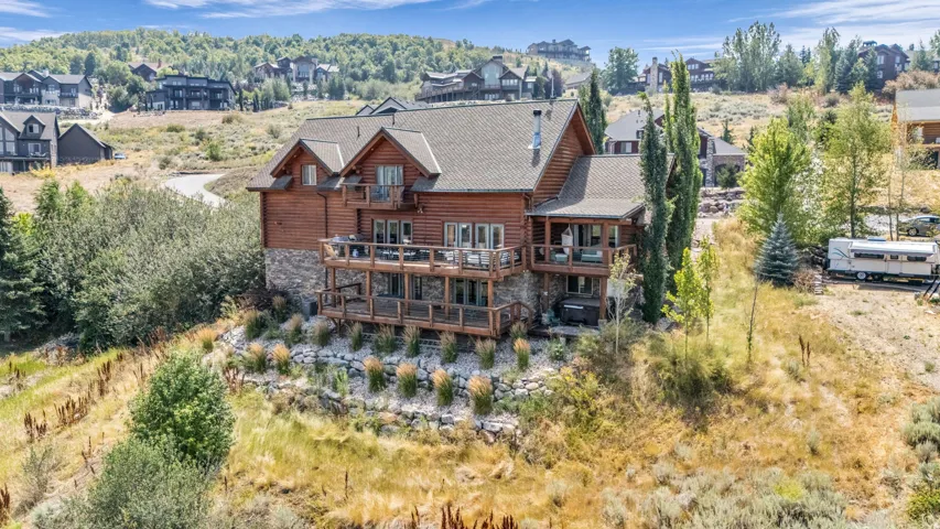 Multi-level residence featuring a wood-sided exterior, stone foundation, and a shingled roof