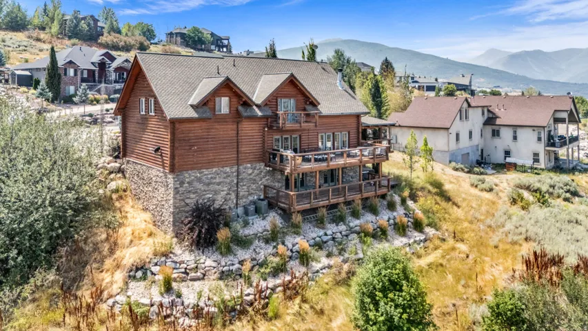 Wood-clad exterior with stone foundation accents, multi-level outdoor decks, and a prominent gable roofline
