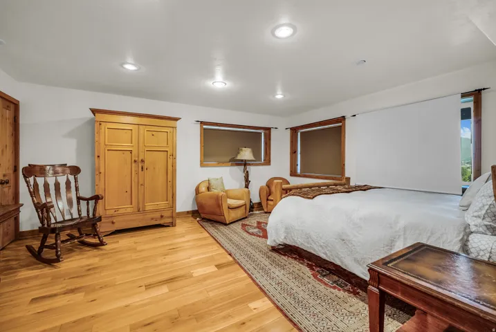 Recessed ceiling lighting, wood-finish flooring, and multiple windows with wood trim