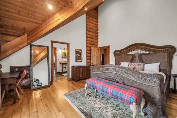 Wood-finish flooring, exposed wood beams, and a log wall accent