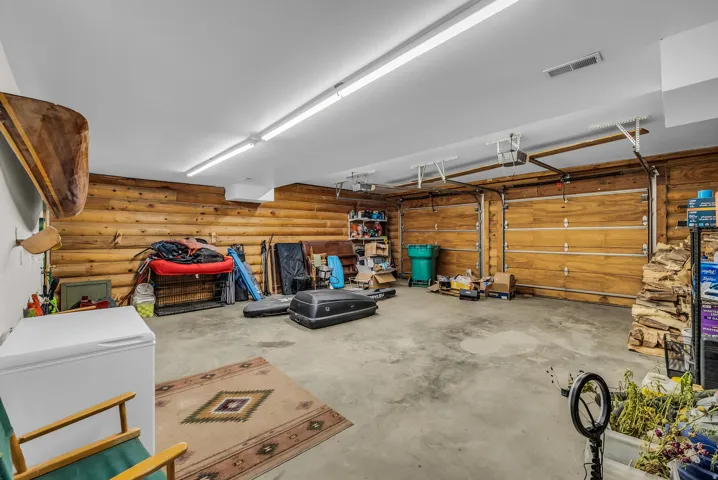 Spacious garage with wood-finish walls and a concrete floor