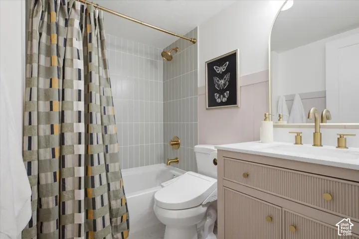 Second bath -white bathtub with light gray vertical tile surround, gold-finish shower fixtures, and a curved shower rod