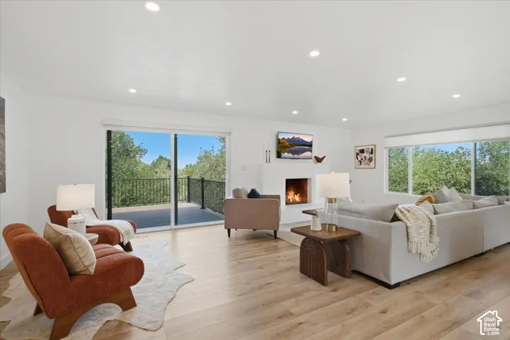 Recessed lighting, wood-finish flooring, a contemporary fireplace, and sliding glass doors opening to the exterior deck for sunset views!