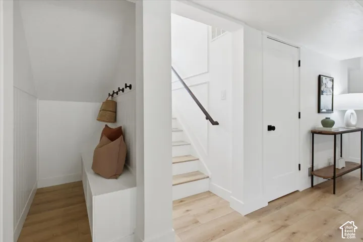 Under-stair alcove featuring a built-in bench and vertical paneling