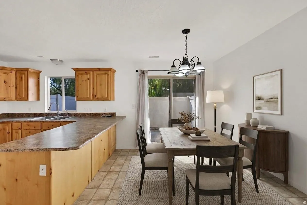 U-shaped kitchen with wood-finish cabinetry, a double basin sink, and a breakfast bar