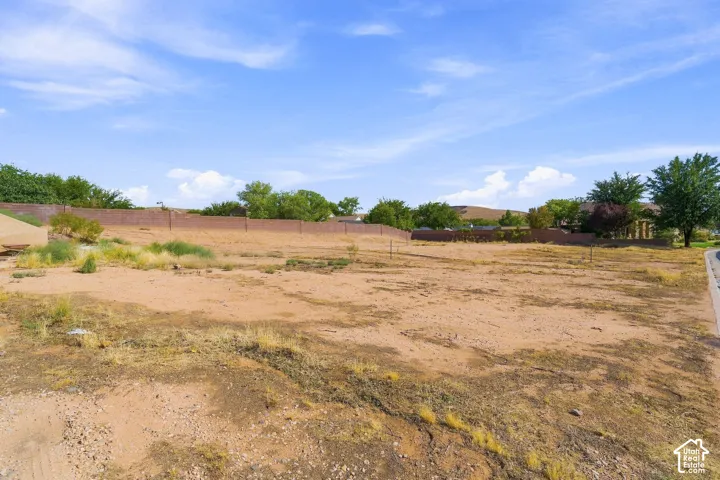 Expansive undeveloped lot with a level grade, surrounded by a perimeter masonry wall