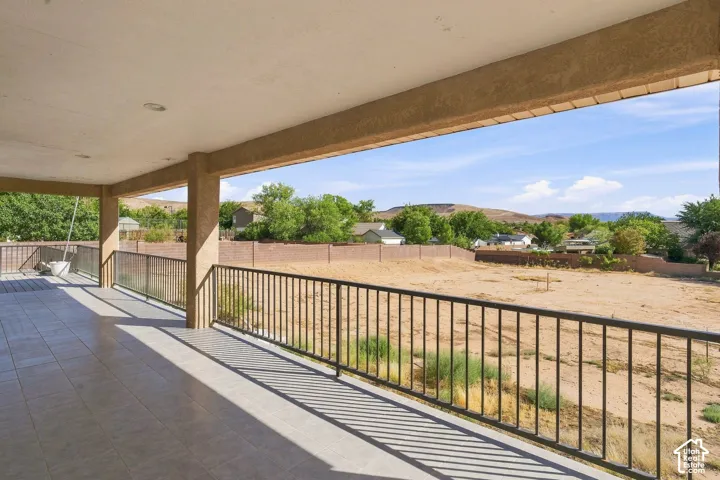 Covered patio with recessed lighting, tiled flooring, and black metal railings
