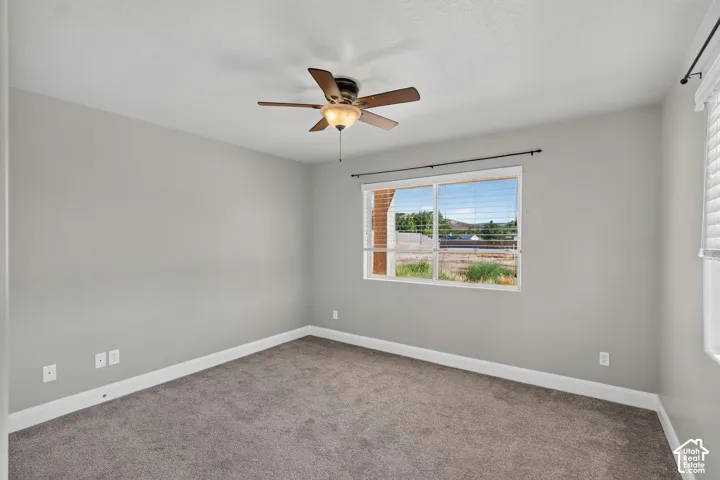 Neutral wall color, ceiling fan with integrated lighting, carpeted flooring, and a window with blinds