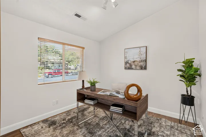 White walls, wood-finish flooring, and recessed lighting