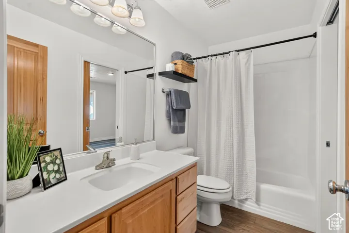 Vanity with wood-finish cabinetry, white countertop, and integrated sink
