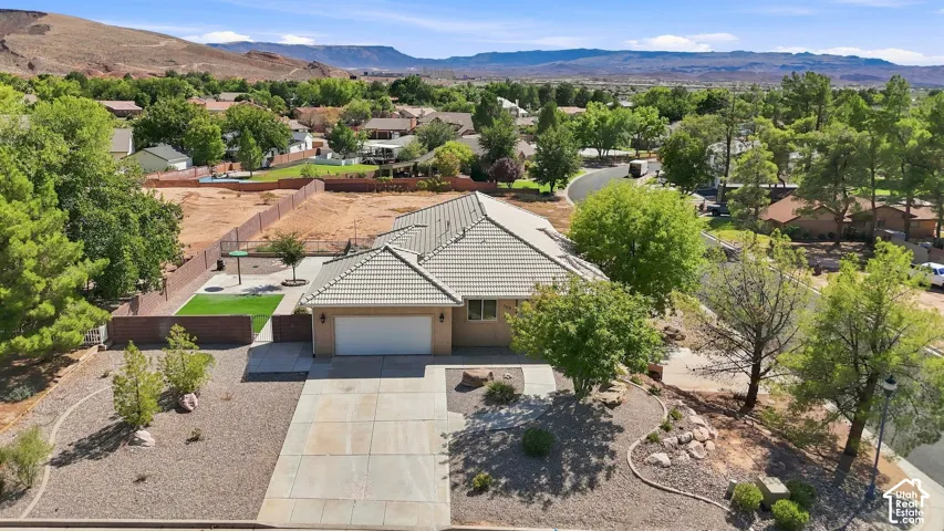 Property featuring a light tile roof, attached garage, and paved driveway