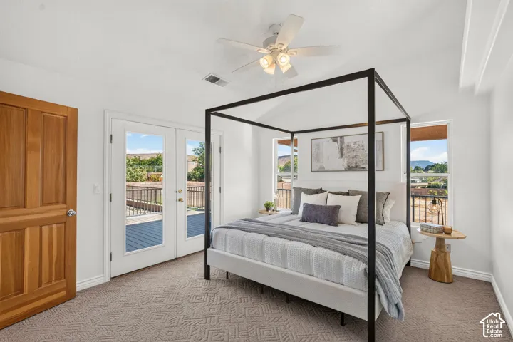 Vaulted ceiling with exposed beams, ceiling fan, and direct access to a private deck through French doors