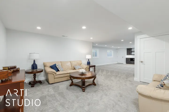 Recessed lighting, light gray carpeting, white walls, and built-in white shutter window treatments