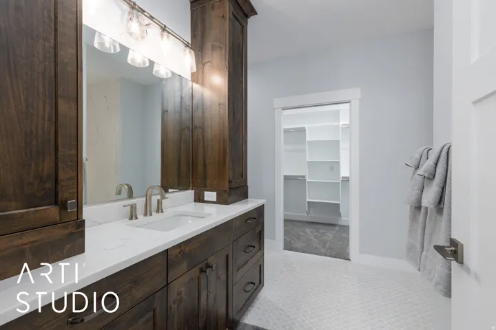 Bathroom vanity featuring a single undermount sink, brushed nickel faucet, and a light-colored countertop