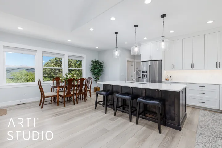 Spacious kitchen and dining area featuring light wood-finish flooring, recessed lighting, and a kitchen island with pendant lighting