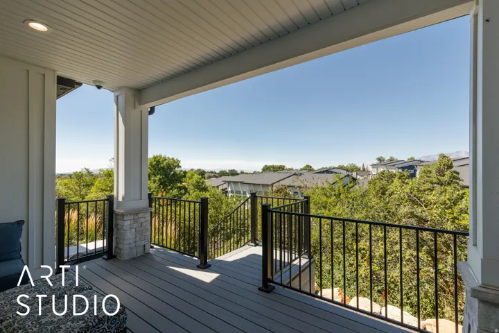 Covered outdoor deck with composite decking, recessed lighting, and black metal railings