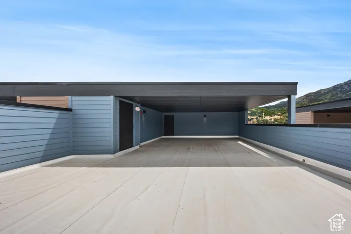 Covered outdoor space featuring composite decking, horizontal siding, and built-in lighting