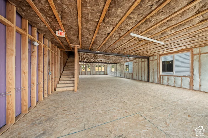 Unfinished interior space with exposed wood framing, ceiling insulation, and plywood subflooring
