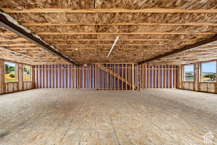 Expansive open space with partial wall framing, insulated ceilings, and multiple windows