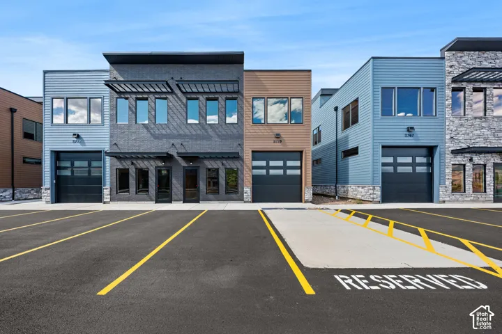 Modern multi-unit structures featuring mixed material exteriors, individual garage doors, and upper-level window arrangements