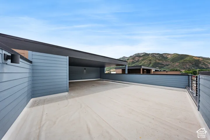 Expansive rooftop deck featuring a covered area, durable concrete surface, and modern horizontal railings