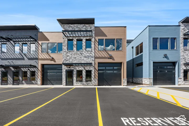 Modern commercial facades featuring stacked stone accents, horizontal siding, and multiple large windows