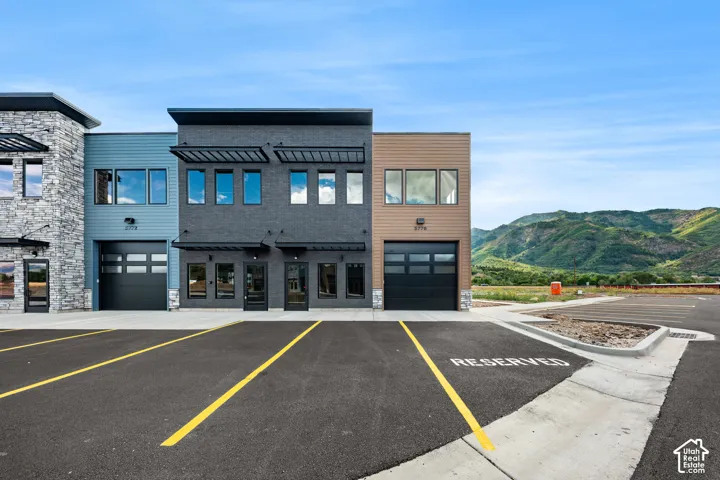 Modern commercial building featuring stone veneer, horizontal siding, and multiple garage doors