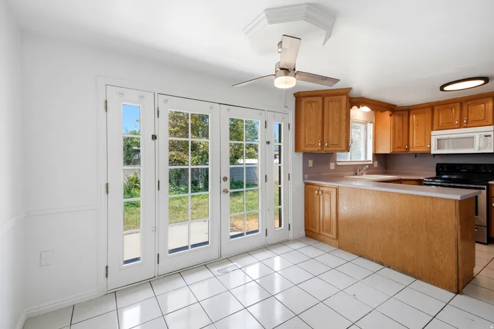 Kitchen with wood-finish cabinetry, light-toned countertops, and a full suite of appliances