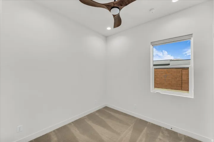 Wall-to-wall carpeting, recessed lighting, and a modern ceiling fan with wood-finish blades