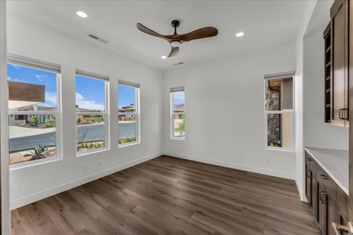 Wood-finish flooring with white walls and recessed lighting