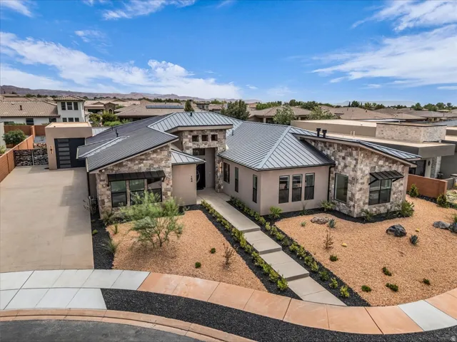 Modern stucco and stone exterior with a metal roof