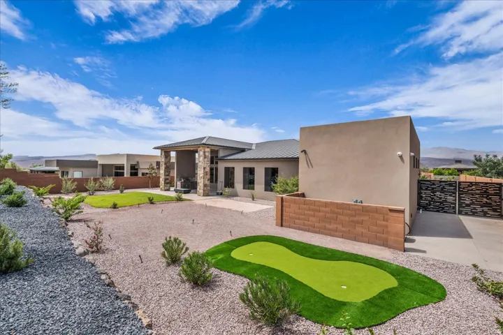 Exterior featuring a stucco facade, stone column accents, and a covered entry